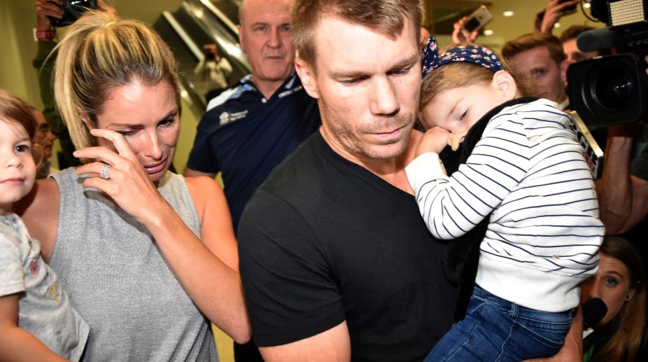 Australian cricketer David Warner (C), his wife Candice and their daughters leave the airport after arriving back in Sydney on March 29, 2018. David Warner apologised on March 29 for his part in a cheating scandal that has shocked the cricketing world and seen sponsors desert the game in Australia, as disgraced skipper Steve Smith heads home to explain his role in the affair. / AFP PHOTO / PETER PARKS